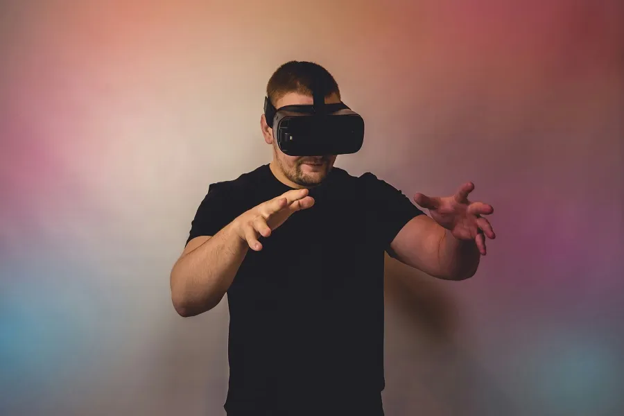 Person in black shirt using virtual reality headset against a colorful background to play modded Android VR games