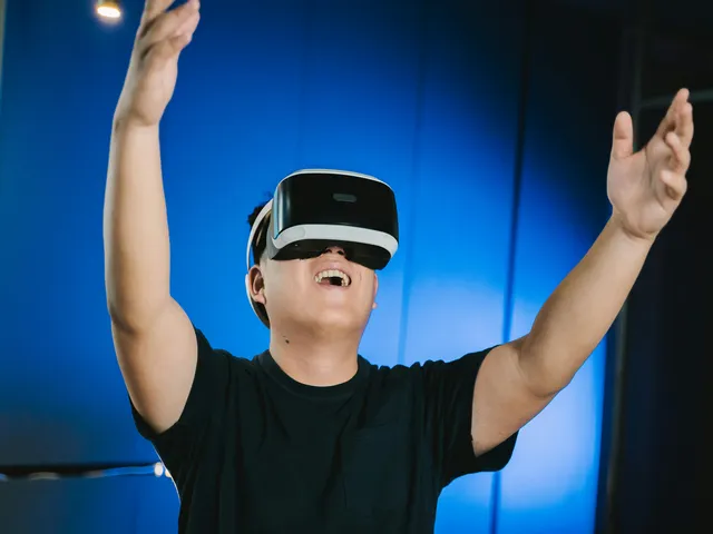 A person wearing a VR headset and playing basketball VR games with blue color in the background